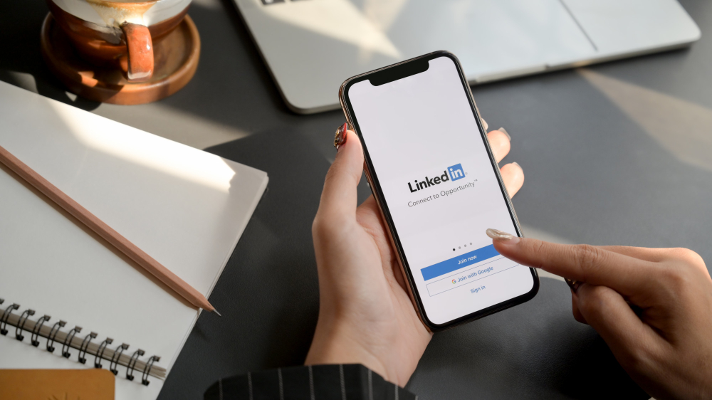 Osoba loguje się do aplikacji LinkedIn na telefonie.